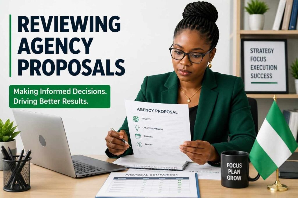 Nigerian business professional reviewing agency proposals at a modern office desk with laptop and documents.
